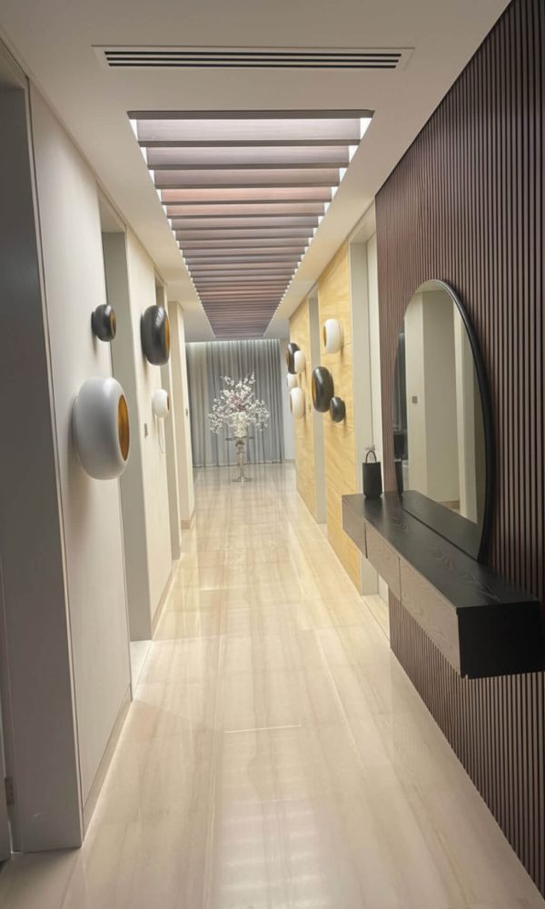 Modern hallway interior design by professional interior designer Shila, featuring a wood slat wall, contemporary wall decor, and an elegant floating console table