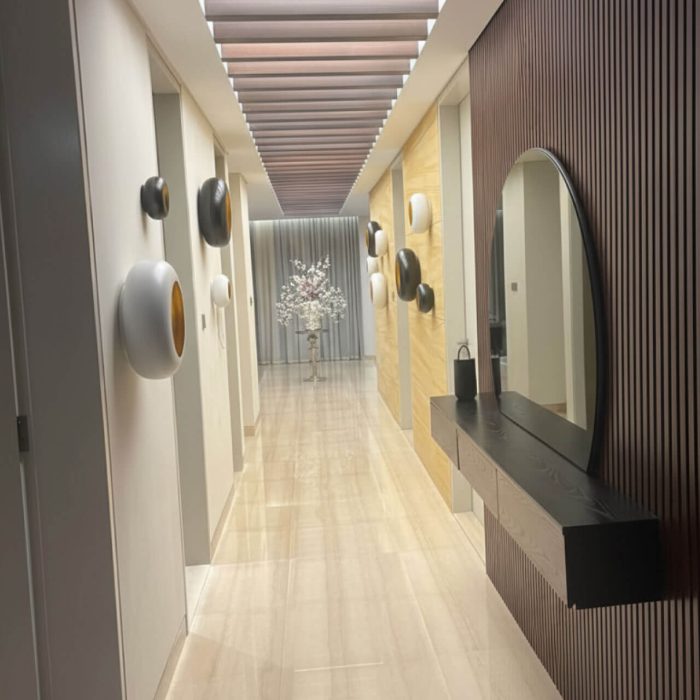 Modern hallway interior design by professional interior designer Shila, featuring a wood slat wall, contemporary wall decor, and an elegant floating console table